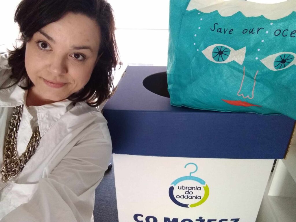 Marta robi sobie selfie z pudełkiem z napisem ubrania do oddania