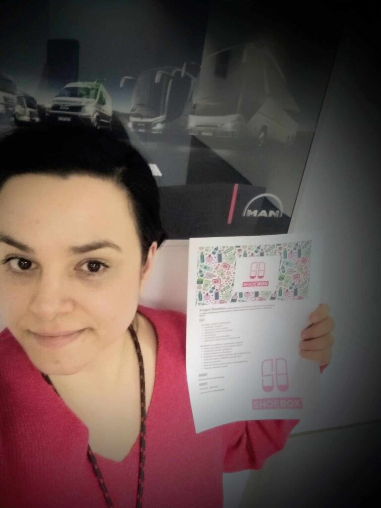 Marta robi selfie. Trzyma w ręką kartkę z napisem shoe box