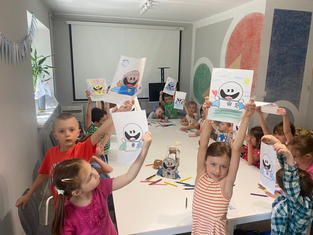 Kolaż trzech zdjęć. Dzieci w sali warsztatowej rusyją postać ducha wielkoducha. Dzieci są w wieku przedszkolnym. Ich prace są pełne kolorów.