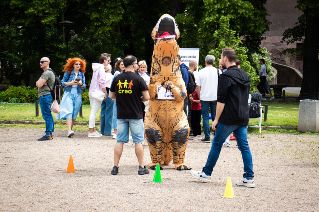 Osoba w przebraniu dinozaura w plenerze